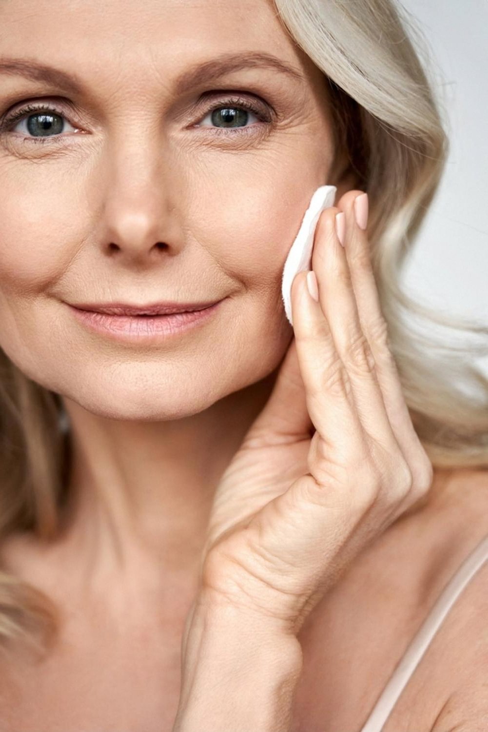 Woman checking her skin at home, close-up of face for AI skin analysis in the UAE