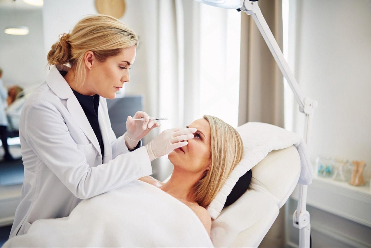 Dermatologist examining a patient's face in a UAE aesthetic clinic