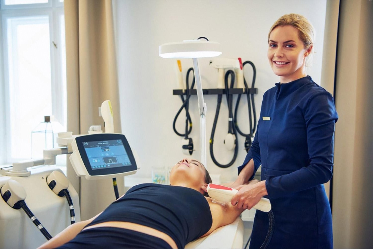 Cosmetologist using a skin treatment device on a client in a Dubai clinic